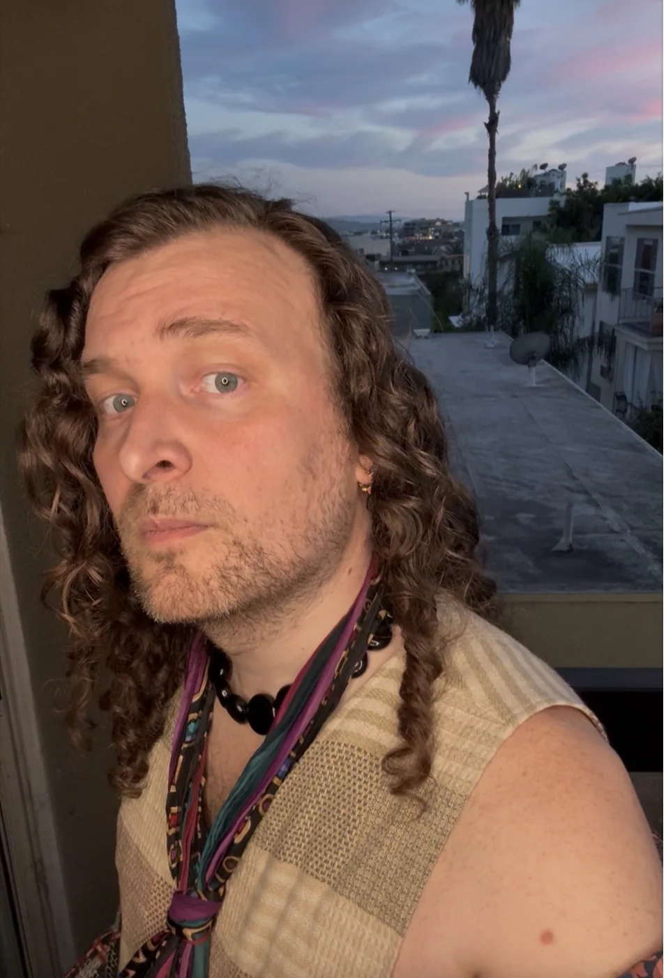 Erik Fuhrer, nonbinary writer and teacher of trauma-informed writing, on a West Hollywood balcony at sunset