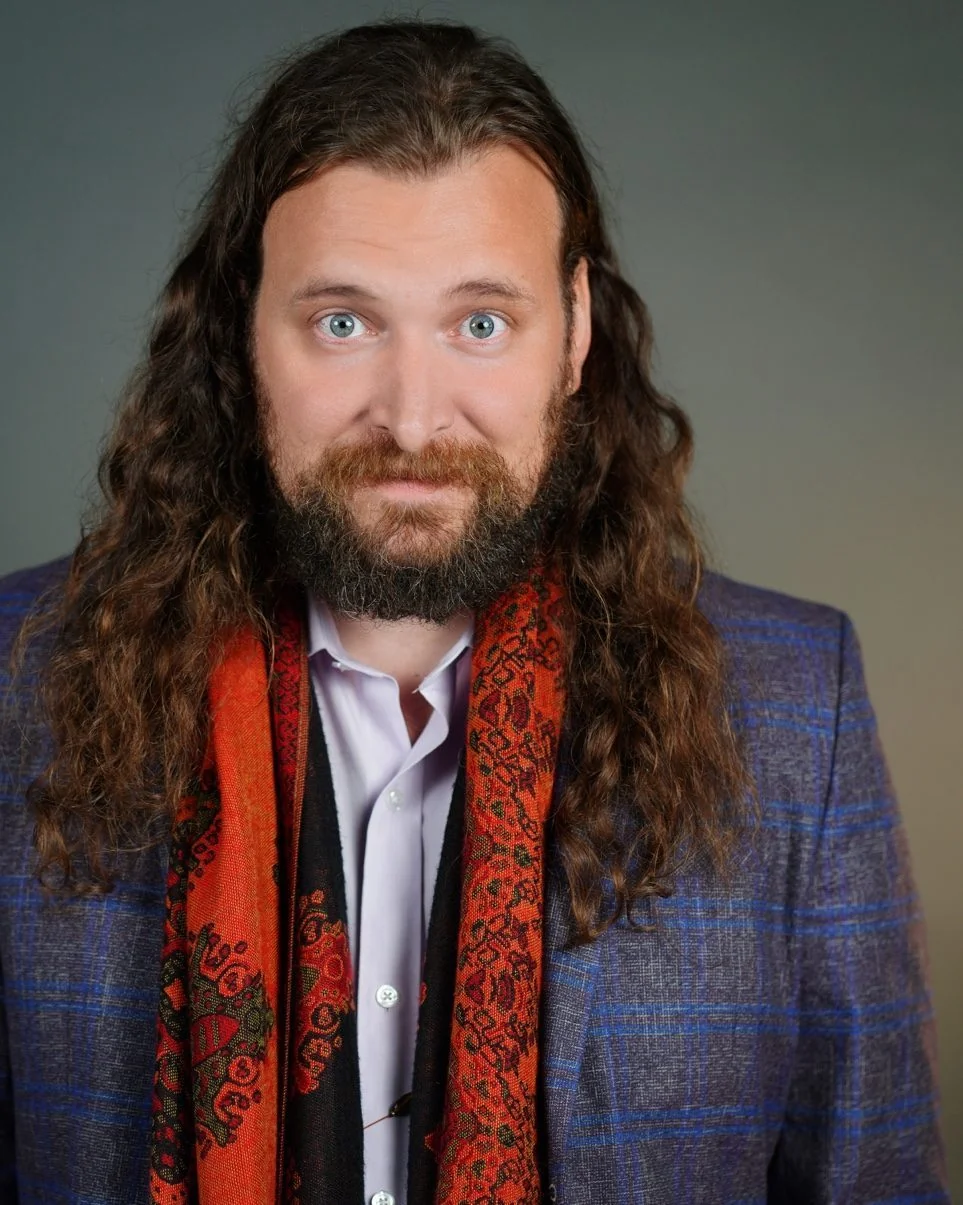 Erik Fuhrer, poet and trauma writing teacher, in a blazer and scarf
