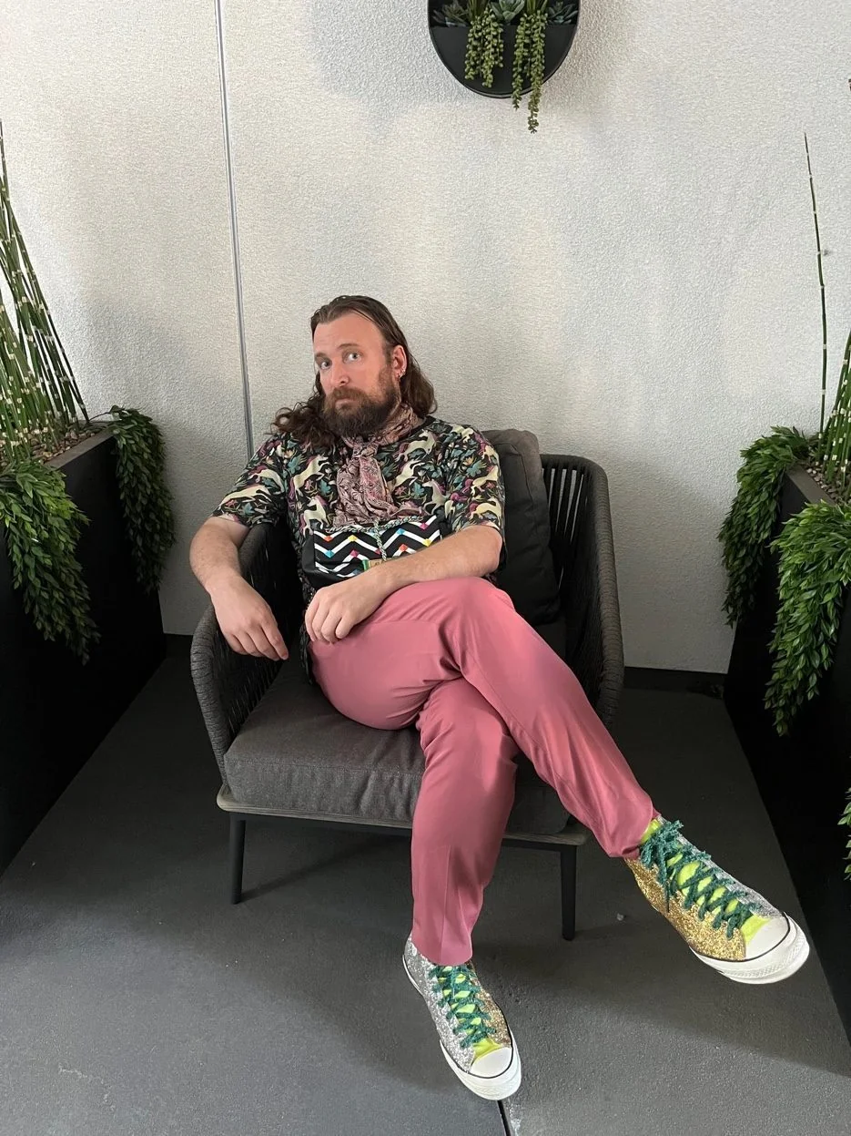 Erik Fuhrer, ghostwriter for therapists, sitting in a chair with plants