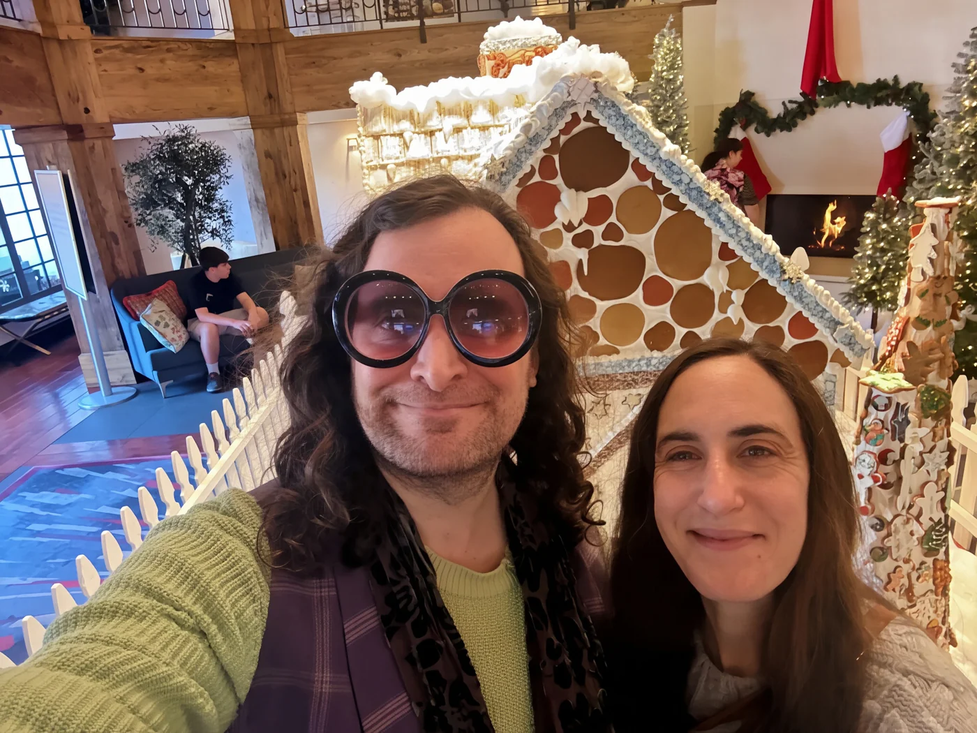 Erik Fuhrer and Kim in front of an edible gingerbread house in Solvang, 2025