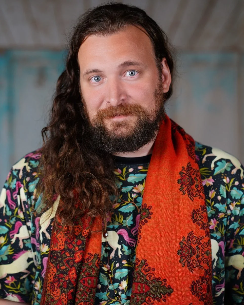 Erik Fuhrer, trauma writing teacher, in a colorful shirt and red scarf